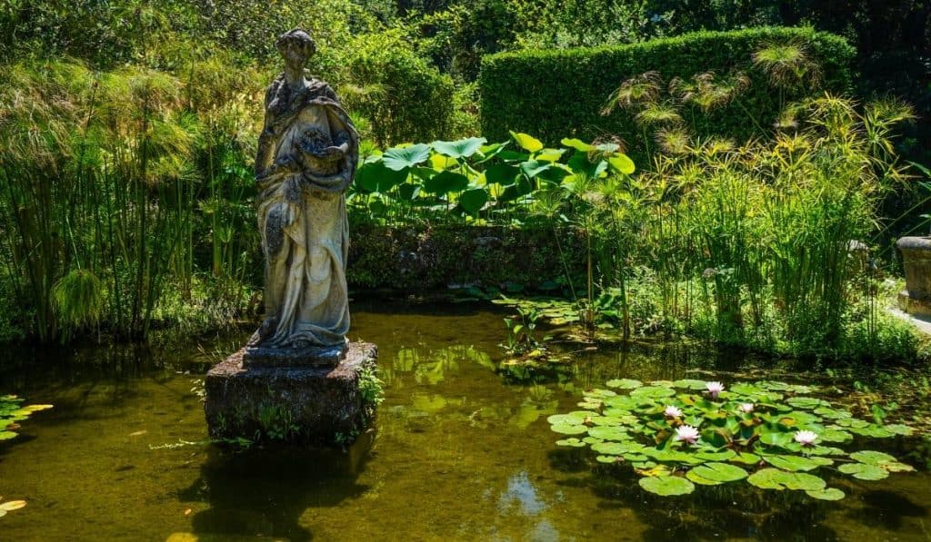 Jardin Serre La Madone with a small pond and eerie looking statue in Menton, France.